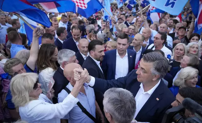Prime Minister incumbent Andrej Plenkovic, right, greets supporters during a rally in Zagreb, Croatia, Sunday, April 14, 2024. Croatia this week holds an early parliamentary election following a campaign that was marked by heated exchanges between the country's two top officials, creating a political crisis in the Balkan country, a European Union and NATO member state. (AP Photo/Darko Bandic)