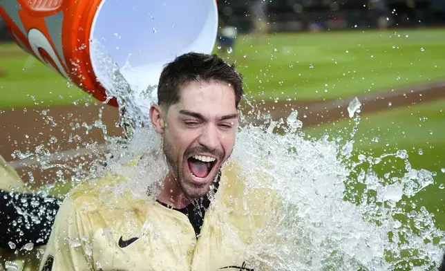 Arizona Diamondbacks' Randal Grichuk gets water dumped on him after his double drove in the winning run against the Chicago Cubs in a baseball game Tuesday, April 16, 2024, in Phoenix. The Diamondbacks won 12-11 in 10 innings. (AP Photo/Ross D. Franklin)