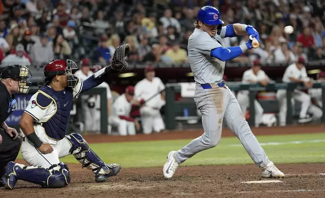 Chicago Cubs' Nico Hoerner connects for an RBI single against the Arizona Diamondbacks during the 11th inning of a baseball game, Monday, April 15, 2024, in Phoenix. (AP Photo/Matt York)