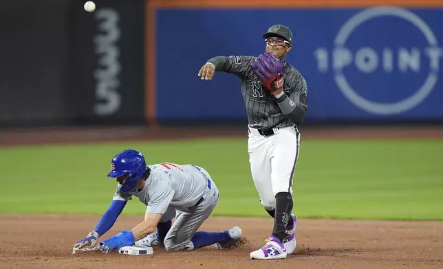 New York Mets' Francisco Lindor, right, throws to first base after forcing out Chicago Cubs' Dansby Swanson, left, during the eighth inning of a baseball game, Monday, April 29, 2024, in New York. Cubs' Matt Mervis was safe at first base on the play. (AP Photo/Frank Franklin II)