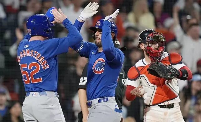 Chicago Cubs' Mike Tauchman, center, celebrates after his three-run home run that also drove in Pete Crow-Armstrong (52) as Boston Red Sox catcher Reese McGuire, right, looks on during the eighth inning of a baseball game, Sunday, April 28, 2024, in Boston. (AP Photo/Michael Dwyer)