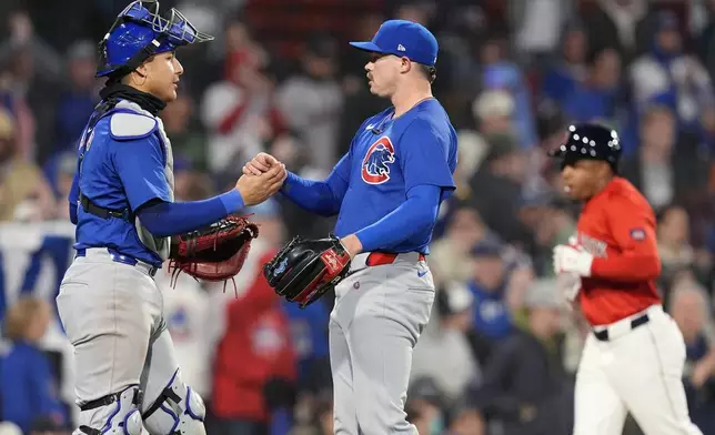 Chicago Cubs relief pitcher Keegan Thompson, center, and catcher Miguel Amaya, left, celebrate after defeating the Boston Red Sox in a baseball game, Friday, April 26, 2024, in Boston. (AP Photo/Michael Dwyer)