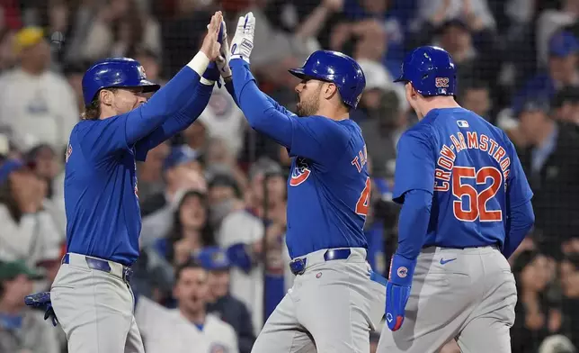 Chicago Cubs' Mike Tauchman, center, celebrates after his three-run home run that also drove in Pete Crow-Armstrong (52) and Nico Hoerner, left, during the eighth inning of a baseball game against the Boston Red Sox, Sunday, April 28, 2024, in Boston. (AP Photo/Michael Dwyer)