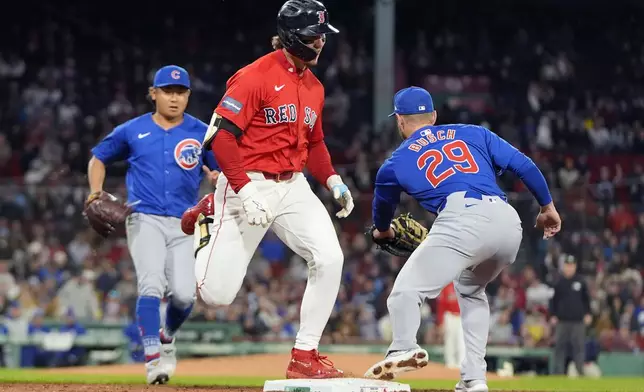 Boston Red Sox's Jarren Duran, center, is out on a bunt after a throw by Chicago Cubs starting pitcher Shota Imanaga, left, to first baseman Michael Busch (29) during the fourth inning of a baseball game, Friday, April 26, 2024, in Boston. (AP Photo/Michael Dwyer)