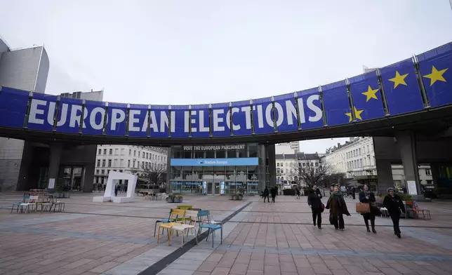 FILE - People walk under a banner advertising the European elections outside the European Parliament in Brussels, on Jan. 24, 2024. The Farmers Defense Force and partners plan to hold one more massive protest of farmers close to EU headquarters in Brussels on June 4. Voting for the elections starts two days later. (AP Photo/Virginia Mayo, File)
