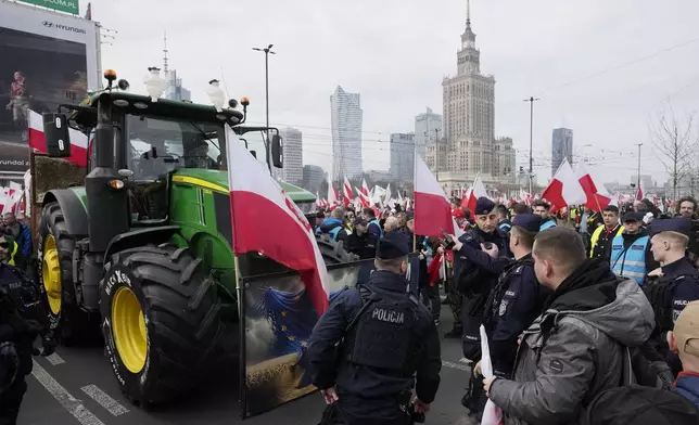 FILE - Polish farmers with national flags and angry slogans written on boards, protest against European Union green policies that trim their production and against cheap grain and other food imports from Ukraine, in Warsaw, Poland, on Feb. 27, 2024. Across the EU, long convoys of tractors have cut off economic lifelines like ports and beltways around major cities, sometimes for days on end, with costs to industry running into the tens of millions daily and keeping hundreds of thousands of people from going to work. (AP Photo/Czarek Sokolowski, File)