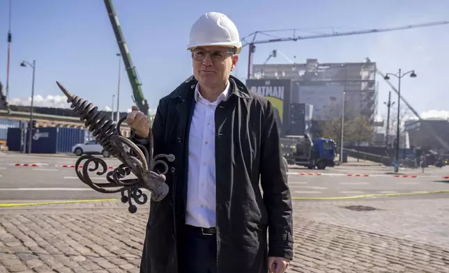Danish Business' CEO Brian Mikkelsen holds the top of the burnt dragon spire in front of Boersen, The Stock Exchange building in Copenhagen Wednesday, April 17, 2024. A fire raged through one of Copenhagen’s oldest buildings on Tuesday, causing the collapse of the iconic spire of the 17th-century Old Stock Exchange as passersby rushed to help emergency services save priceless paintings and other valuables. (Ida Marie Odgaard/Ritzau Scanpix)