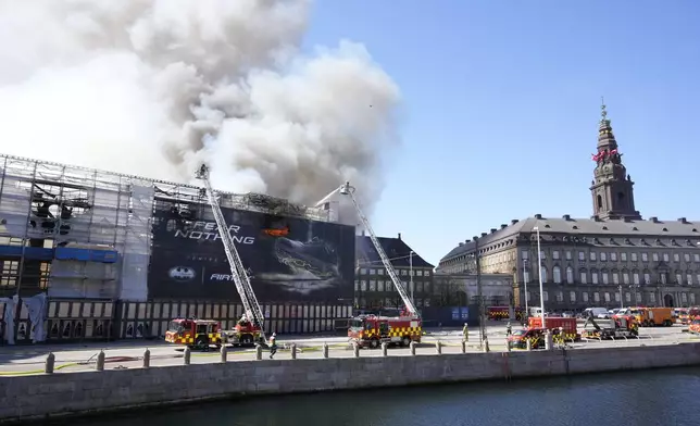 Firefighters work as smoke rise out of the Old Stock Exchange, Boersen, in Copenhagen, Denmark, Tuesday, April 16, 2024. One of Copenhagen’s oldest buildings is on fire and its iconic spire has collapsed. The building, which is situated next to the Christiansborg Palace where the parliament sits, is a popular tourist attraction. Its distinctive spire, in the shape of the tails of four dragons twined together, reached a height of 56 meters (184 feet). (Emil Helms/Ritzau Scanpix via AP)