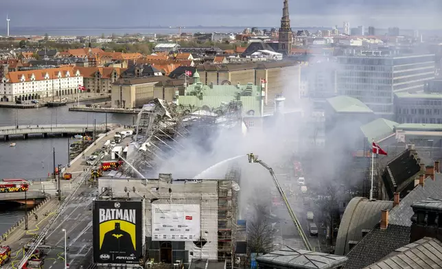 Firefighters work on the building after a fire broke out at the Stock Exchange in Copenhagen, Tuesday, April 16, 2024. The fire was reported Tuesday morning in the historic building, which was undergoing renovation. (Ida Marie Odgaard/Ritzau Scanpix)