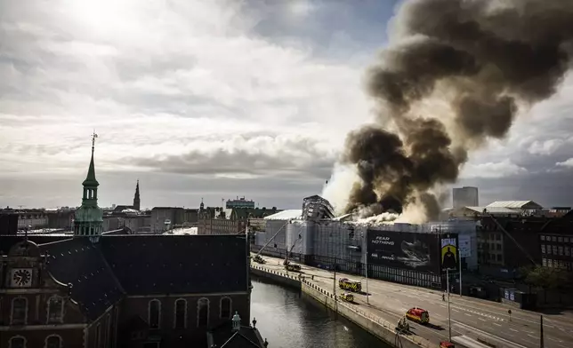 Firefighters work at the scene as smoke rises from the Stock Exchange in Copenhagen, Denmark, Tuesday, April 16, 2024. A fire raged through one of Copenhagen’s oldest buildings on Tuesday, causing the collapse of the iconic spire of the 17th-century Old Stock Exchange as passersby rushed to help emergency services save priceless paintings and other valuables. (Emil Nicolai Helms/Ritzau Scanpix via AP)