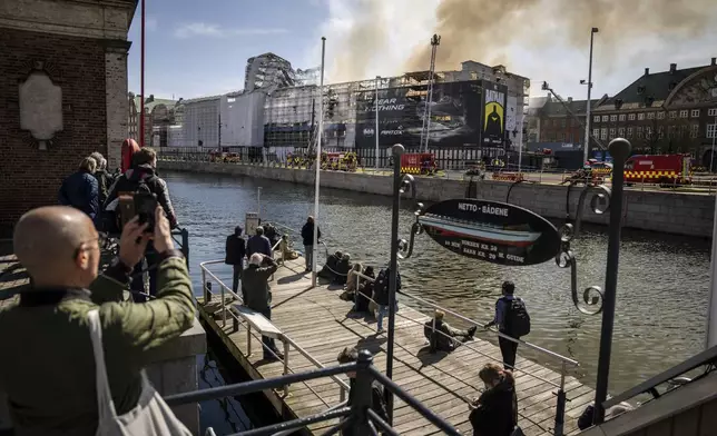 Firefighters work on the building after a fire broke out at the Stock Exchange in Copenhagen, Tuesday, April 16, 2024. The fire was reported Tuesday morning in the historic building, which was undergoing renovation. (Mads Claus Rasmussen/Ritzau Scanpix)