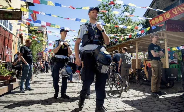 FILE - Police patrol Pusher Street in at Christiania, Copenhagen, May 25, 2018, after the street reopened after having been closed for three days. The aging hippies who more than 50 years ago squatted a derelict naval base in Copenhagen and turned it into freewheeling Christiania neighborhood, want to boot out criminals controlling the community's lucrative hashish market for good, by ripping open the paved street on Saturday, April 6, 2024, where small brown lumps openly change hands and which has been a thorn in side of many. (Nils Meilvang/Ritzau Scanpix via AP, File)