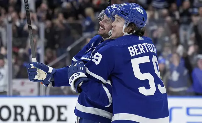 Toronto Maple Leafs center Auston Matthews, left, celebrates his goal against the New Jersey Devils with Tyler Bertuzzi during the second period of an NHL hockey game Thursday, April 11, 2024, in Toronto. (Nathan Denette/The Canadian Press via AP)