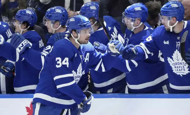 Toronto Maple Leafs center Auston Matthews (34) is congratulated for his goal against the New Jersey Devils during the first period of an NHL hockey game Thursday, April 11, 2024, in Toronto. (Nathan Denette/The Canadian Press via AP)