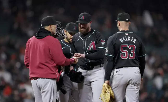 Arizona Diamondbacks pitcher Bryce Jarvis, center, hands the ball over to manager Torey Lovullo during the seventh inning of the team's baseball game against the San Francisco Giants, Thursday, April 18, 2024, in San Francisco. (AP Photo/Godofredo A. Vásquez)