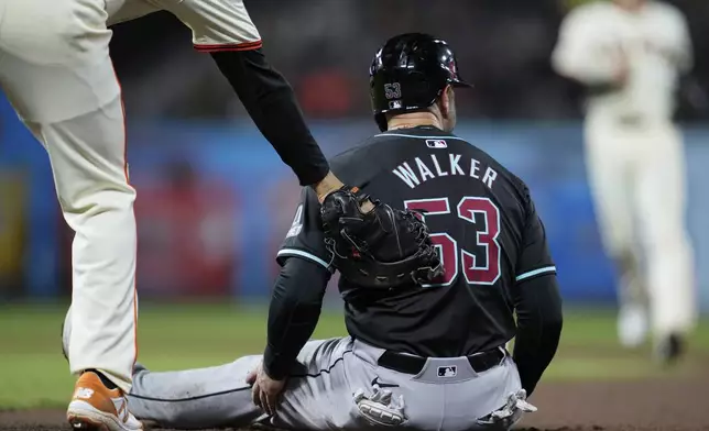 Arizona Diamondbacks' Christian Walker (53) is tagged out by San Francisco Giants first baseman LaMonte Wade Jr. after being caught off first during the seventh inning of a baseball game Thursday, April 18, 2024, in San Francisco. (AP Photo/Godofredo A. Vásquez)