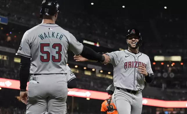 Arizona Diamondbacks' Christian Walker (53) celebrates with Eugenio Suárez after they scored on a double by Gabriel Moreno against the San Francisco Giants during the seventh inning of a baseball game Friday, April 19, 2024, in San Francisco. (AP Photo/Jeff Chiu)