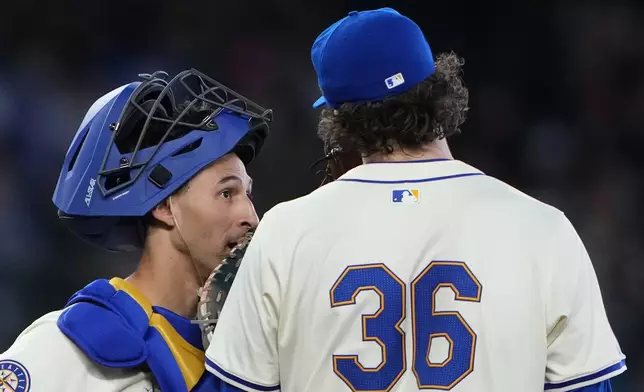 Seattle Mariners catcher Seby Zavala, left, talks with starting pitcher Logan Gilbert during the seventh inning of a baseball game against the Arizona Diamondbacks, Sunday, April 28, 2024, in Seattle. (AP Photo/Lindsey Wasson)