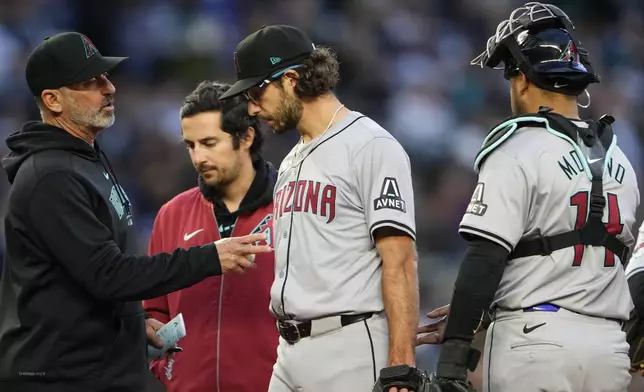 Arizona Diamondbacks manager Torey Lovullo, left, talks with starting pitcher Zac Gallen, who leaves the game with an injury, while catcher Gabriel Moreno, right, watches during the sixth inning of the team's baseball game against the Seattle Mariners, Friday, April 26, 2024, in Seattle. (AP Photo/Lindsey Wasson)