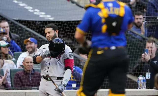 Arizona Diamondbacks' Eugenio Suárez, left, winks at Seattle Mariners catcher Cal Raleigh, right, as he receives an ovation on deck during the second inning of a baseball game Friday, April 26, 2024, in Seattle. (AP Photo/Lindsey Wasson)
