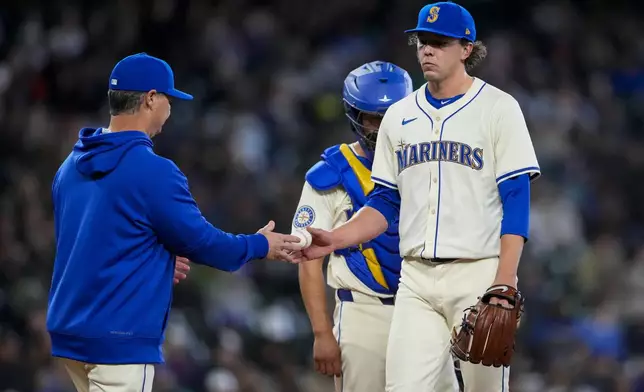Seattle Mariners manager Scott Servais, left, takes the ball from starting pitcher Logan Gilbert as he is relieved from the game against the Arizona Diamondbacks during the seventh inning of a baseball game Sunday, April 28, 2024, in Seattle. (AP Photo/Lindsey Wasson)