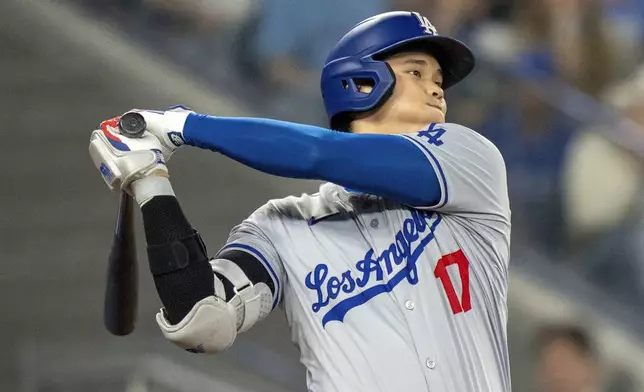 Los Angeles Dodgers designated hitter Shohei Ohtani hits a line drive to second base during fourth-inning baseball game action against the Toronto Blue Jays in Toronto, Sunday, April 28, 2024. (Frank Gunn/The Canadian Press via AP)