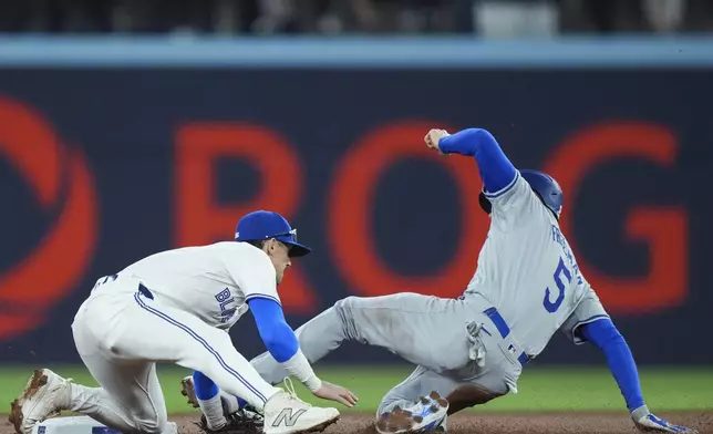 Toronto Blue Jays second baseman Cavan Biggio (8) tags out Los Angeles Dodgers' Freddie Freeman (5) at second base on a steal attempt during the first inning of a baseball game Friday, April 26, 2024, in Toronto. (Nathan Denette/The Canadian Press via AP)