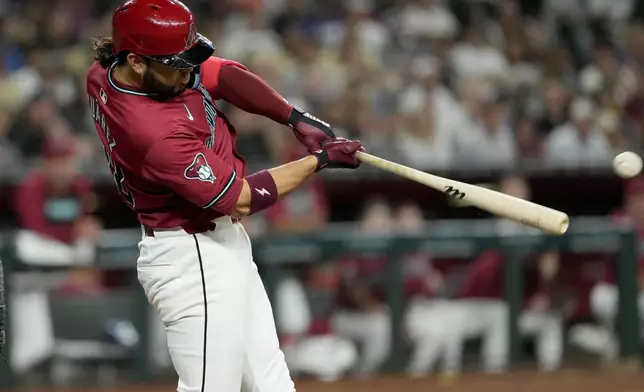 Arizona Diamondbacks third base Eugenio Suárez connects for an RBI base hit during the fifth inning of a baseball game against the Los Angeles Dodgers, Monday, April 29, 2024, in Phoenix. (AP Photo/Matt York)