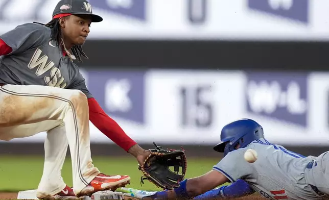 Washington Nationals shortstop CJ Abrams, left, waits for the throw as Los Angeles Dodgers' Miguel Rojas steals second base during the third inning of a baseball game at Nationals Park, Tuesday, April 23, 2024, in Washington. (AP Photo/Alex Brandon)