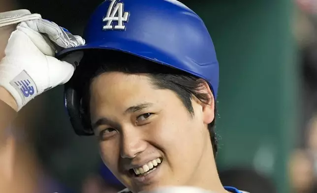 Los Angeles Dodgers designated hitter Shohei Ohtani smiles after he celebrates his solo home run during the ninth inning of a baseball game against the Washington Nationals at Nationals Park, Tuesday, April 23, 2024, in Washington. The Dodgers won 4-1. (AP Photo/Alex Brandon)