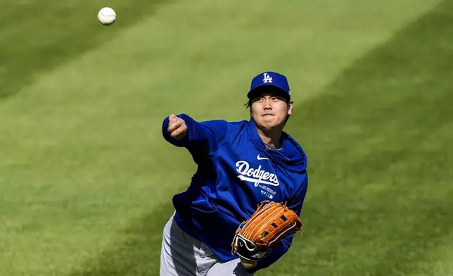 Los Angeles Dodgers' Shohei Ohtani throws before a baseball game against the Washington Nationals at Nationals Park, Tuesday, April 23, 2024, in Washington. (AP Photo/Alex Brandon)