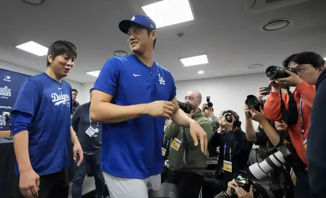 FILE - Los Angeles Dodgers' Shohei Ohtani, right, and his interpreter, Ippei Mizuhara, leave after a news conference ahead of a baseball workout at Gocheok Sky Dome in Seoul, South Korea, March 16, 2024. The former longtime interpreter for Los Angeles Dodgers star Shohei Ohtani has been charged with federal bank fraud for crimes involving gambling debts and theft of millions of dollars from the slugger. Federal authorities announced the development Thursday, April 11, at a press conference in Los Angeles. (AP Photo/Lee Jin-man, File)