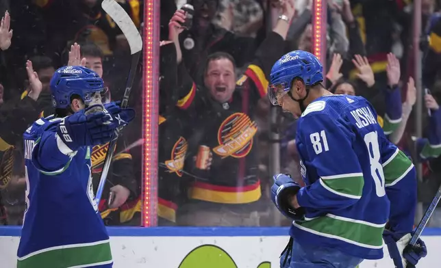 Vancouver Canucks' Dakota Joshua, right, and Conor Garland celebrate Dakota's second goal against the Anaheim Ducks, during the third period of an NHL hockey game Sunday, March 31, 2024, in Vancouver, British Columbia. (Darryl Dyck/The Canadian Press via AP)