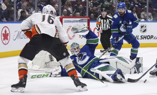 Vancouver Canucks goalie Arturs Silovs, center, makes the save as Filip Hronek, back right, and Anaheim Ducks' Ryan Strome (16) watch during the second period of an NHL hockey game in Vancouver, British Columbia, on Sunday, March 31, 2024. (Darryl Dyck/The Canadian Press via AP)