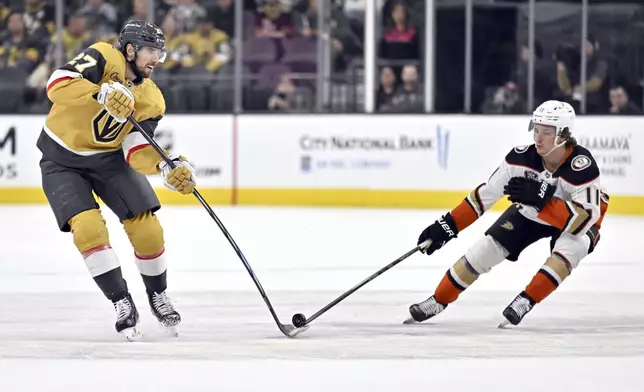 Vegas Golden Knights defenseman Shea Theodore (27) and Anaheim Ducks center Trevor Zegras (11) vie for the puck during the second period of an NHL hockey game Thursday, April 18, 2024, in Las Vegas. (AP Photo/David Becker)