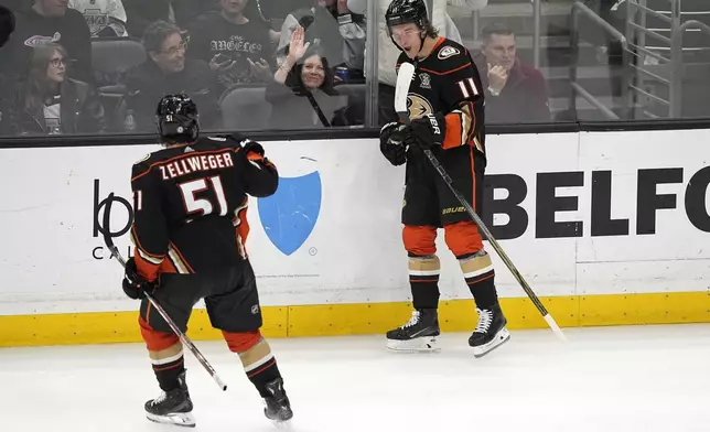 Anaheim Ducks center Trevor Zegras, right, celebrates his goal with defenseman Olen Zellweger during the third period of an NHL hockey game against the Los Angeles Kings Saturday, April 13, 2024, in Los Angeles. (AP Photo/Mark J. Terrill)