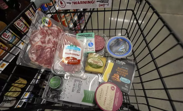 An assortment of vegan, organic, locally sourced, and wild caught food products all using plastic packaging, sit in a shopping cart at a grocery store in New Orleans, Wednesday, April 17, 2024. People are increasingly breathing, eating and drinking tiny particles of plastic, however, there are simple things people can do at the grocery store if they want to use less plastic. (AP Photo/Gerald Herbert)
