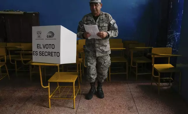 An Air Force officer votes in a referendum proposed by President Daniel Noboa to endorse new security measures aimed at cracking down on criminal gangs fueling escalating violence, in Quito, Ecuador, Sunday, April 21, 2024. (AP Photo/Dolores Ochoa)