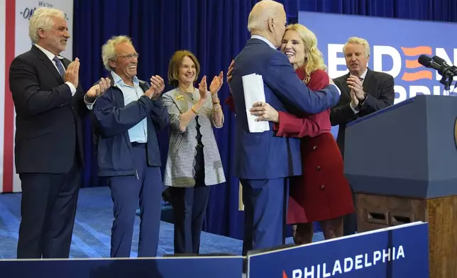 Kerry Kennedy, second right, hugs President Joe Biden at a campaign event, Thursday, April 18, 2024, in Philadelphia. Pictured from left are members of the Kennedy family Maxwell Kennedy Sr., Joe Kennedy III, Kathleen Kennedy Townsend and Christopher Kennedy. (AP Photo/Alex Brandon)