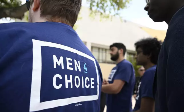 Supporters wear shirts with the message "Men 4 Choice" while waiting in line to see President Joe Biden speak during a reproductive freedom campaign event at Hillsborough Community College, Tuesday, April 23, 2024, in Tampa, Fla. (AP Photo/Phelan M. Ebenhack)
