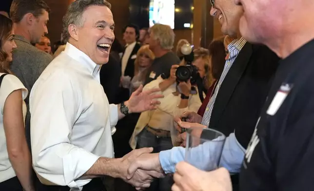 Republican David McCormick, left, making his second bid for a Pennsylvania U.S. Senate seat, greets supporters at his election night watch party in Pittsburgh, Tuesday, April 23, 2024. (AP Photo/Gene J. Puskar)