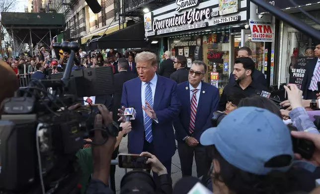 Former president Donald Trump, talks to members of the media while visiting a bodega, Tuesday, April 16, 2024, who's owner was attacked last year in New York. Fresh from a Manhattan courtroom, Donald Trump visited a New York bodega where a man was stabbed to death, a stark pivot for the former president as he juggles being a criminal defendant and the Republican challenger intent on blaming President Joe Biden for crime. Alba's attorney, Rich Cardinale, second from left, and Fransisco Marte, president of the Bodega Association, looked on. (AP Photo/Yuki Iwamura)