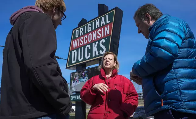 Wisconsin Democratic U.S. Sen. Tammy Baldwin talks to Dan Gavinski, right, and Chase Slack before riding a Wisconsin Dells Duck during a campaign stop Friday, March 29, 2024, in Wisconsin Dells, Wis. The stop was part of her campaign launch tour in a race against Republican Eric Hovde the could determine who has majority control of the Senate. The Wisconsin Senate race between Democratic Sen. Tammy Baldwin and Republican Eric Hovde is setting up as one of the most competitive and expensive Senate races in the country. (AP Photo/Morry Gash)