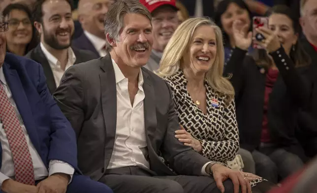 With his wife Sharon at his side Madison, Wis., businessman and Republican U.S. Senate candidate, Eric Hovde smile and laugh after being acknowledged, Tuesday April 2, 2024, at a former President Donald Trump rally in Green Bay, Wis. The Wisconsin Senate race between Democratic Sen. Tammy Baldwin and Republican Eric Hovde is setting up as one of the most competitive and expensive Senate races in the country. (AP Photo/Mike Roemer)