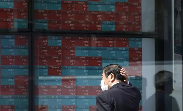 FILE - A person looks at an electronic stock board showing Japan's stock princes at a securities firm in Tokyo, April 2, 2024. Asian benchmarks extended gains Tuesday, April 23, after U.S. stocks clawed back a chunk of their losses from the previous week. (AP Photo/Eugene Hoshiko, File)