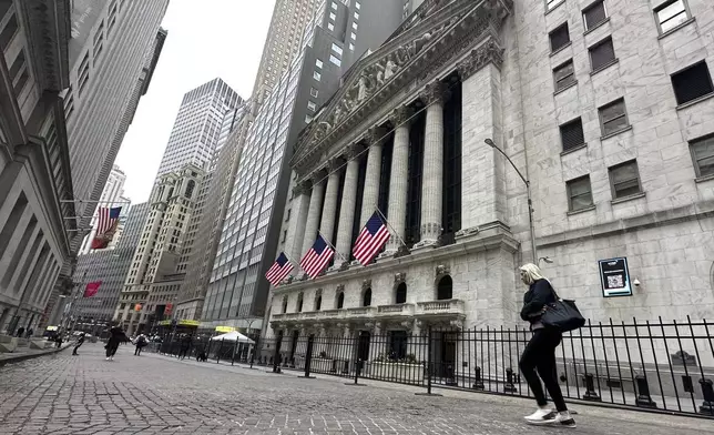 A person passes the New York Stock Exchange on Tuesday, April 30, 2024 in New York. Global shares are trading mostly higher as investors keep their eyes on potentially market-moving reports expected later this week. (AP Photo/Peter Morgan)