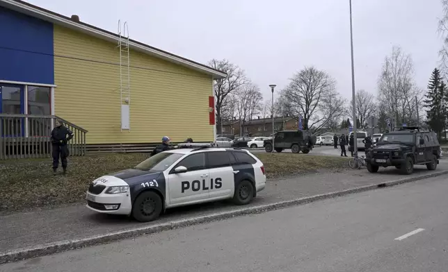 Police officers and vehicles at the scene of Viertola comprehensive school, in Vantaa, Finland, Tuesday, April 2, 2024. Finnish police say a number of people were wounded in a shooting at a school outside Helsinki and a suspect was detained. (Markku Ulander/Lehtikuva via AP)