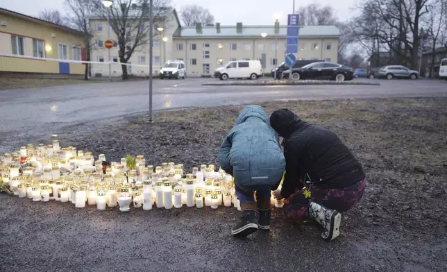 People bring candles and flowers at the Viertola school in Vantaa, Finland, Tuesday April 2, 2024, after a shooting incident. A 12-year-old student opened fire at a secondary school in southern Finland on Tuesday morning, killing one and seriously wounded two other students, police said. The suspect was later arrested. (Roni Rekomaa/Lehtikuva via AP)