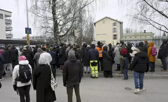 Family members of pupils of the Viertola comprehensive school wait to enter the school, in Vantaa, Finland, Tuesday, April 2, 2024. A 12-year-old student opened fire at a secondary school in southern Finland on Tuesday morning, killing one and seriously wounded two other students, police said. The suspect was later arrested. (Markku Ulander/Lehtikuva via AP)