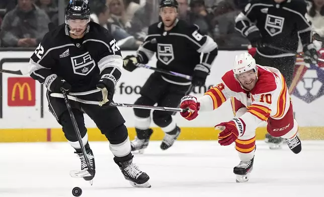 Los Angeles Kings left wing Kevin Fiala, left, takes the puck as Calgary Flames center Jonathan Huberdeau reaches in during the second period of an NHL hockey game Thursday, April 11, 2024, in Los Angeles. (AP Photo/Mark J. Terrill)
